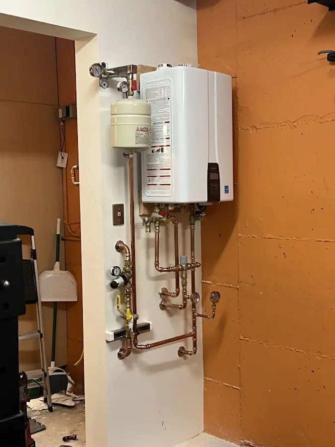 Plumbing technician inspecting water heater connections in Manhattan